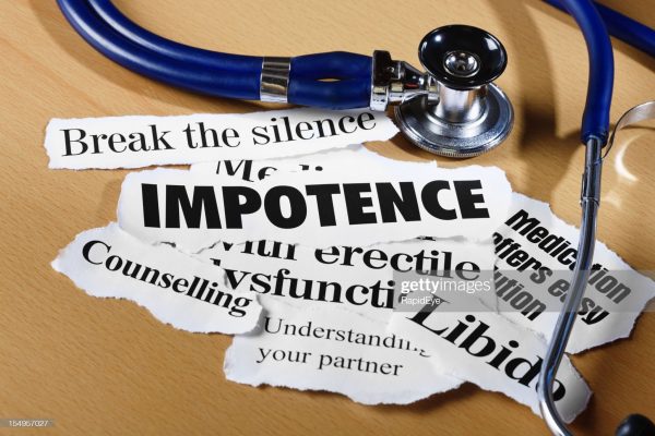 Press headlines on impotence issues and what to do about them,  with a stethoscope, on a wooden desk.